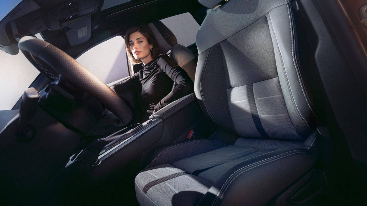 Primer plano del asiento del conductor del interior delantero del nuevo Opel Grandland, con una mujer sentada en el asiento del acompañante